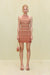 Woman wearing an knit mini dress that features a high neck, made of orange tonal stripes. 
