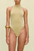 Close up of a woman wearing a metallic gold knit bodysuit that features a high neck and a high cut leg, paired with a gold bangle. 