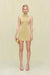 Woman wearing a gold knit mini dress that features a high neck, paired with all gold accessories. 