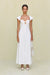 Woman wearing a white maxi poplin dress that features a sweetheart neck, cap sleeves, and a cutout at the bust, paired with white sandals. 