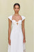 Close up of a woman wearing a white maxi poplin dress that features a sweetheart neck, cap sleeves, and a cutout at the bust, paired with white sandals. 