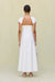 Back view of a woman wearing a white maxi poplin dress that features an open back and cap sleeves. 