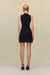 Back view of a woman wearing a black mini dress that features a high neck with cutouts in the midriff. 