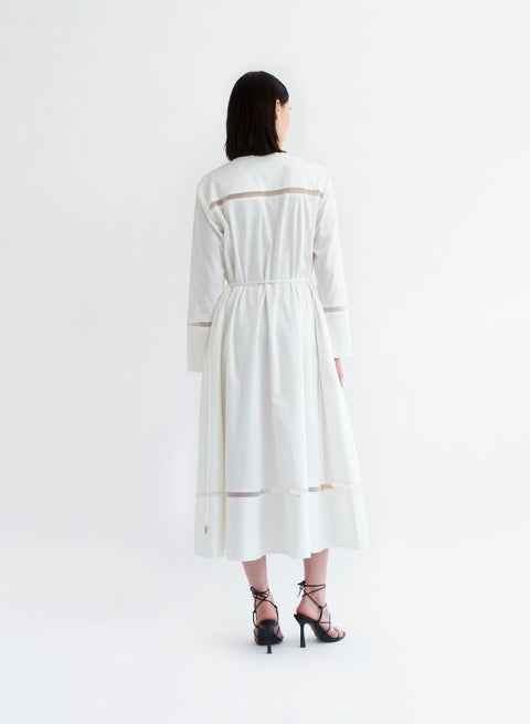 Model faces away showing the back of the ivory reborn ladder trim midi dress.