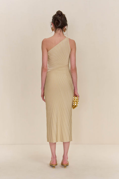 Back view of a woman wearing a cream knit midi dress that features a one-shoulder neckline and patterned ribbing. 
