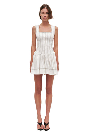 Woman wearing a white mini dress on a white background