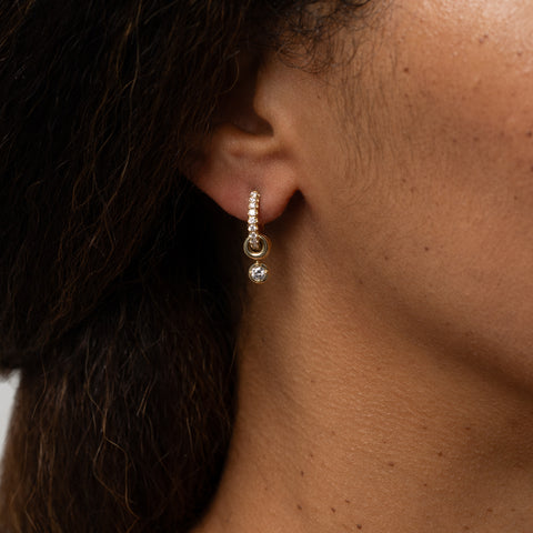 Close up of a woman wearing a Spinelli Kilcollin Zahra Pave White Diamond earring. 