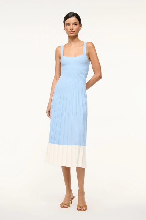 Woman wearing a light blue knit midi dress that features corset-style ribbing and white color blocking on the bottom