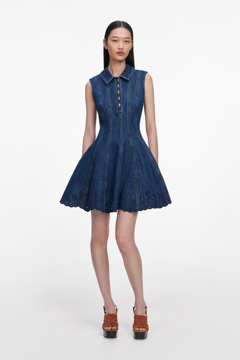 Woman wearing a blue denim collared mini dress on a white background