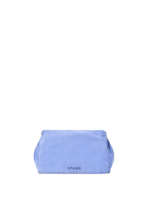 A light blue velvet pouch bag with the brand name 'STAUD' printed in black on the front, centered against a solid white background.