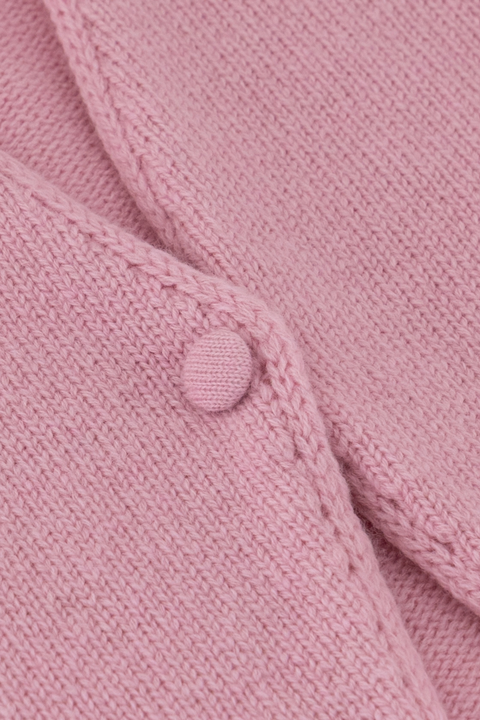 Close up of button closdure on pink sweater. 