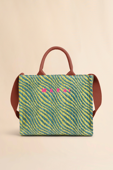 Handbag with a green and yellow striped pattern and pink text on a beige background