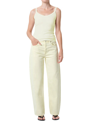 Person wearing a light green tank top and matching mid-rise, wide leg pants on a white background with hand in pocket 