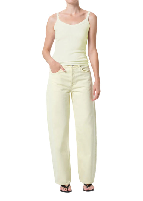Person wearing a light green tank top and matching mid-rise, wide leg pants on a white background with hand in pocket 