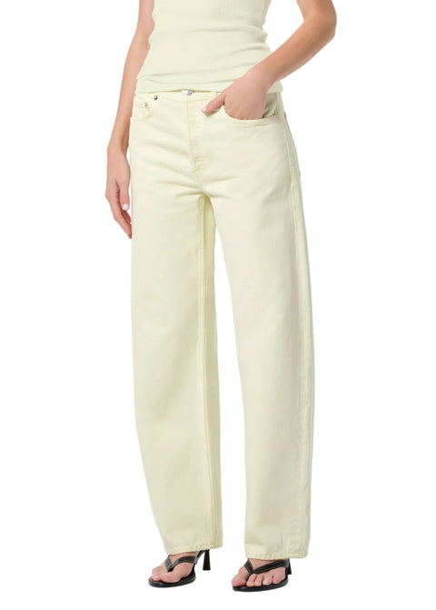 Person wearing a light green tank top and matching mid-rise, wide leg pants on a white background with hand in pocket off-center view 