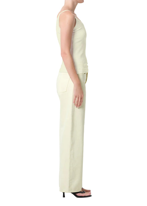 Person wearing a light green tank top and matching mid-rise, wide leg pants on a white background from the side