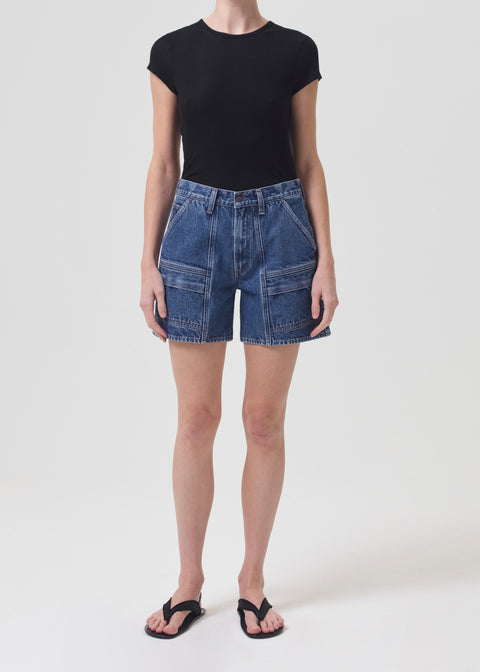 Model facing the camera in the blue denim cargo shorts with a black tee