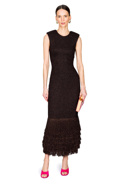 Woman posing wearing a brown dress with a textured pattern on a white background