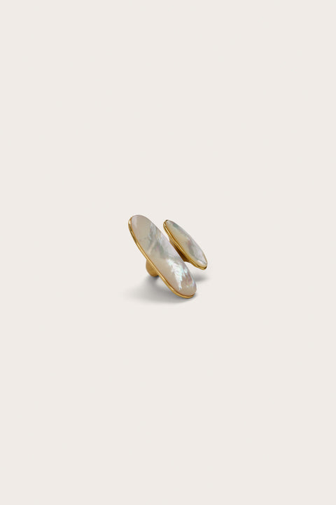 Side view of an ended design statement ring that features one small and one larger mother of pearl inlays on each end of the gold ring. 