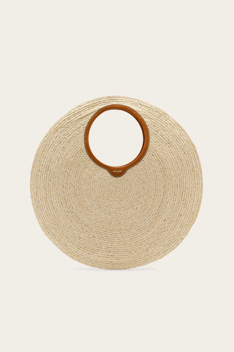 Oversized, circular woven handbag with a tan leather handle lining. 