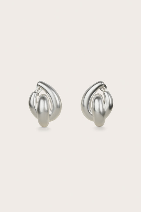 A pair of silver-toned clip-on statement earrings that feature interlocking abstract hoops.