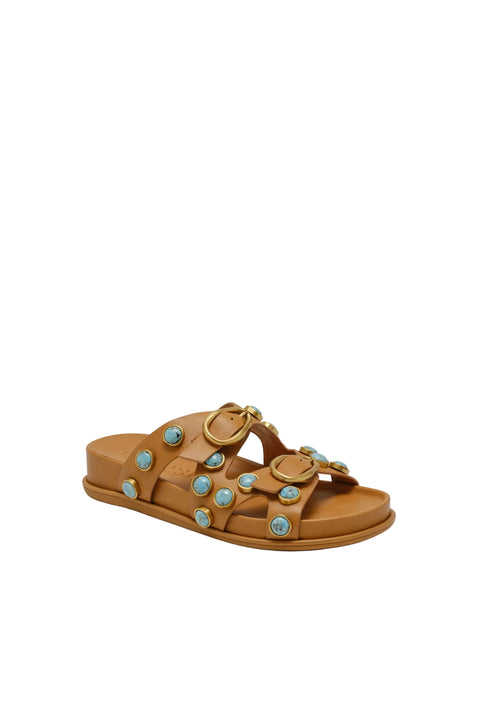 Tan sandal with decorative elements on a beige background