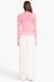 Model facing the back in the pink and white cardigan