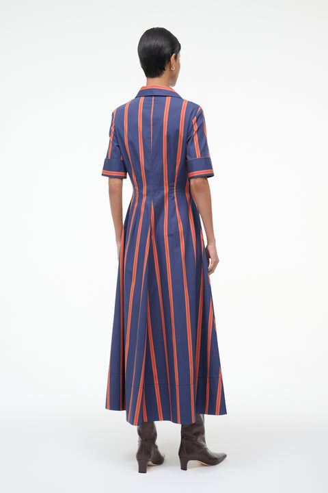 Back-facing woman wearing a blue and orange striped dress on a white background