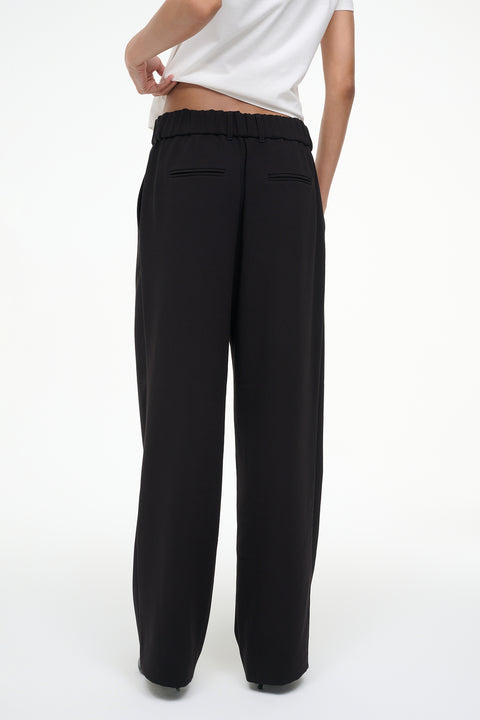 Black wide-leg pants worn by a person on a white background