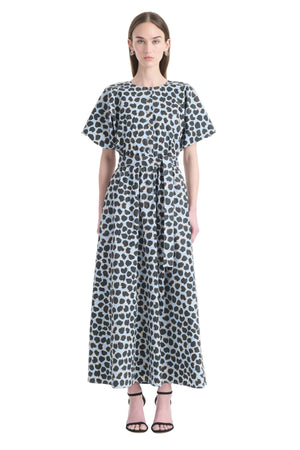 Woman wearing a blue polka dot maxi dress with short sleeves on a white background