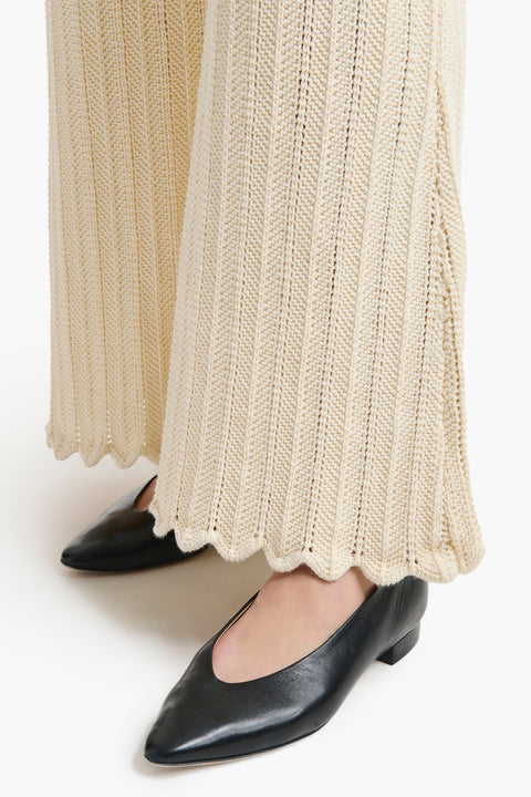 Up close of scalloped hem on the cream knitted pants.