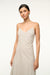 Up close of a woman wearing a v-neck ivory with brown stripes maxi dress that features a side pleat and ruching at the hip, paired with brown sandals. 