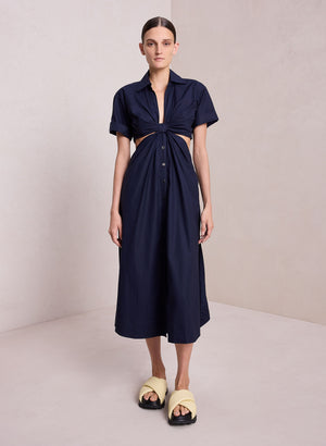 Model facing the camera in the navy blue midi dress with side cutouts