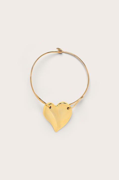 A gold-toned choker that features a large abstract heart pendant fixed on a neck wire with a hook clasp. 