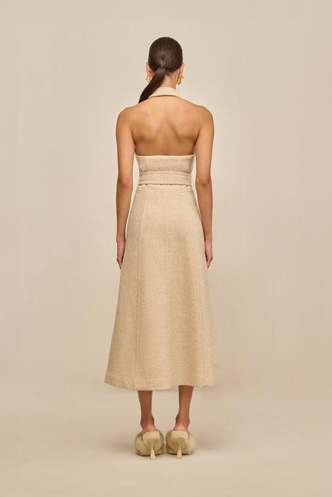 Woman wearing a beige strapless dress on a beige background