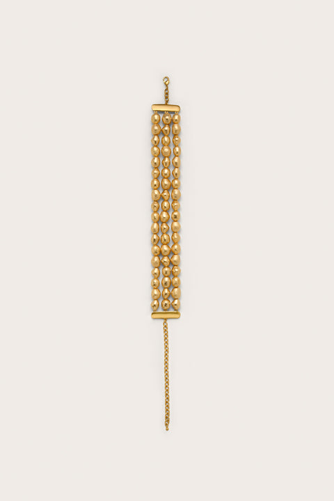 A choker style necklace crafted from three rows of gold-foiled wooden beads and gold hardware. 