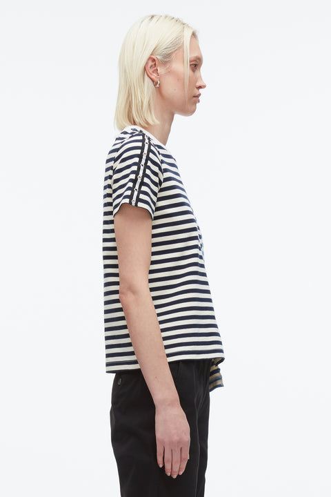 Woman facing right showing striped sleeve of t-shirt with gromet detail.