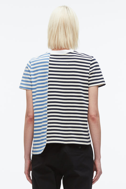 Back of woman wearing striped patchwork t-shirt with asymmetrical hem.