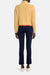 Model facing the back in the yellow wool turtleneck sweater