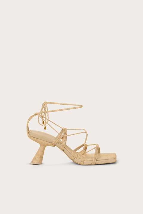 Side-facing raffia heel that features a gladiator-style lace up design with a unique comma heel. 