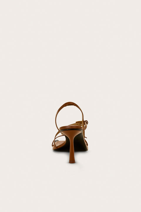 Back view of a brown strappy heel that features two gold buckle details and a slingback strap. 