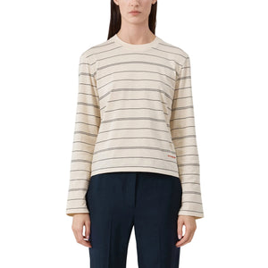 Woman wearing a striped long sleeve t-shirt and dark pants on a light background