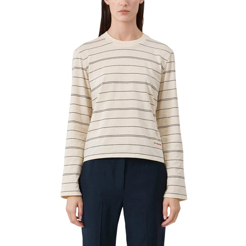 Woman wearing a striped long sleeve t-shirt and dark pants on a light background