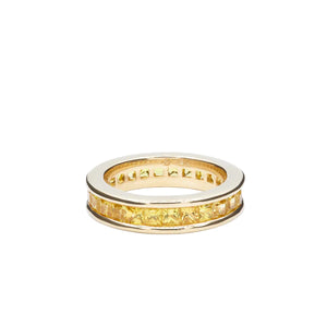 Yellow sapphire and yellow gold ring on a white background