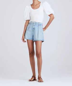 Model shot from the neck down wearing the josie high rise pleated short in vintage light wash.