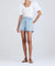 Model shot from the neck down wearing the josie high rise pleated short in vintage light wash.