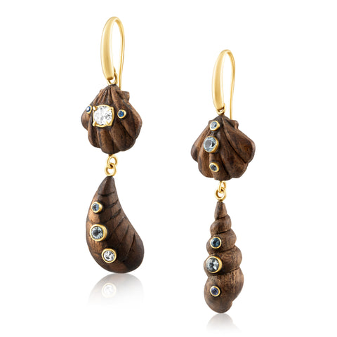 Side view of wooden shell earrings with gold and gemstone accents on a white 