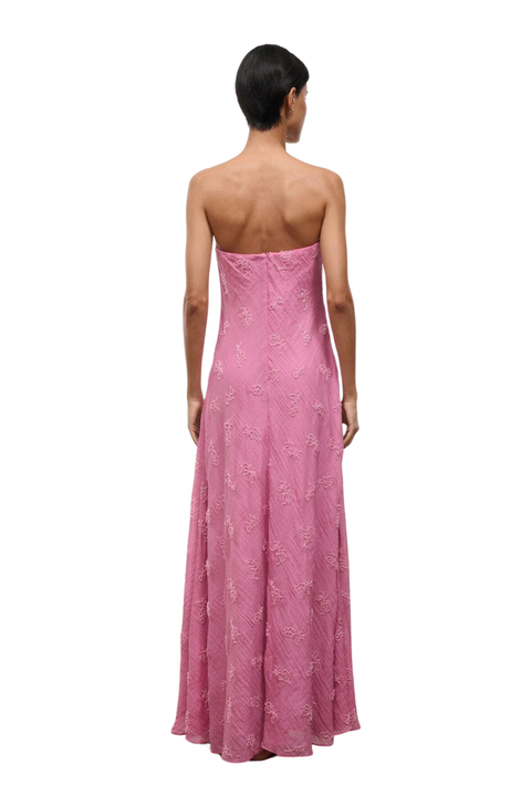 A woman wearing a strapless pink maxi dress with beaded embellishments back  angle