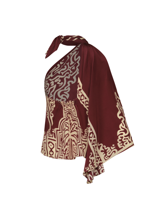 A burgundy and ecru patterned top with one draped sleeve and a halter tie-neck