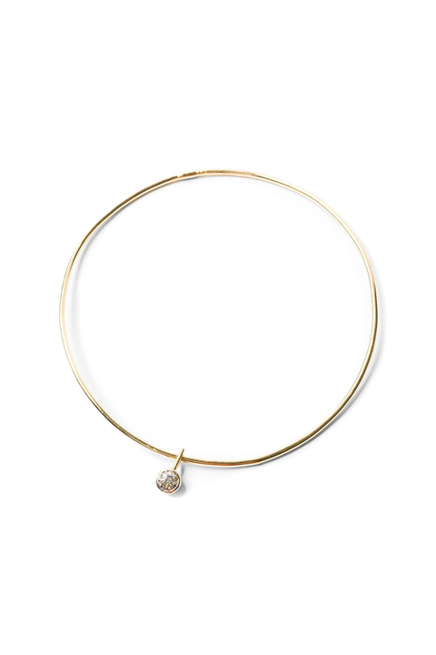 Gold necklace with a small diamond pendant on a white background